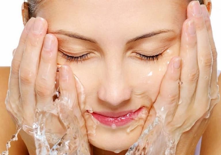 Làm sạch da mặt bằng nước tinh khiết hoặc nước muối